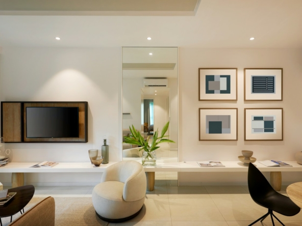 A modern living room with a television, armchair, and framed abstract art